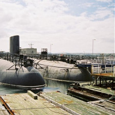 HMS Conqueror na základně, plavidlo napravo.